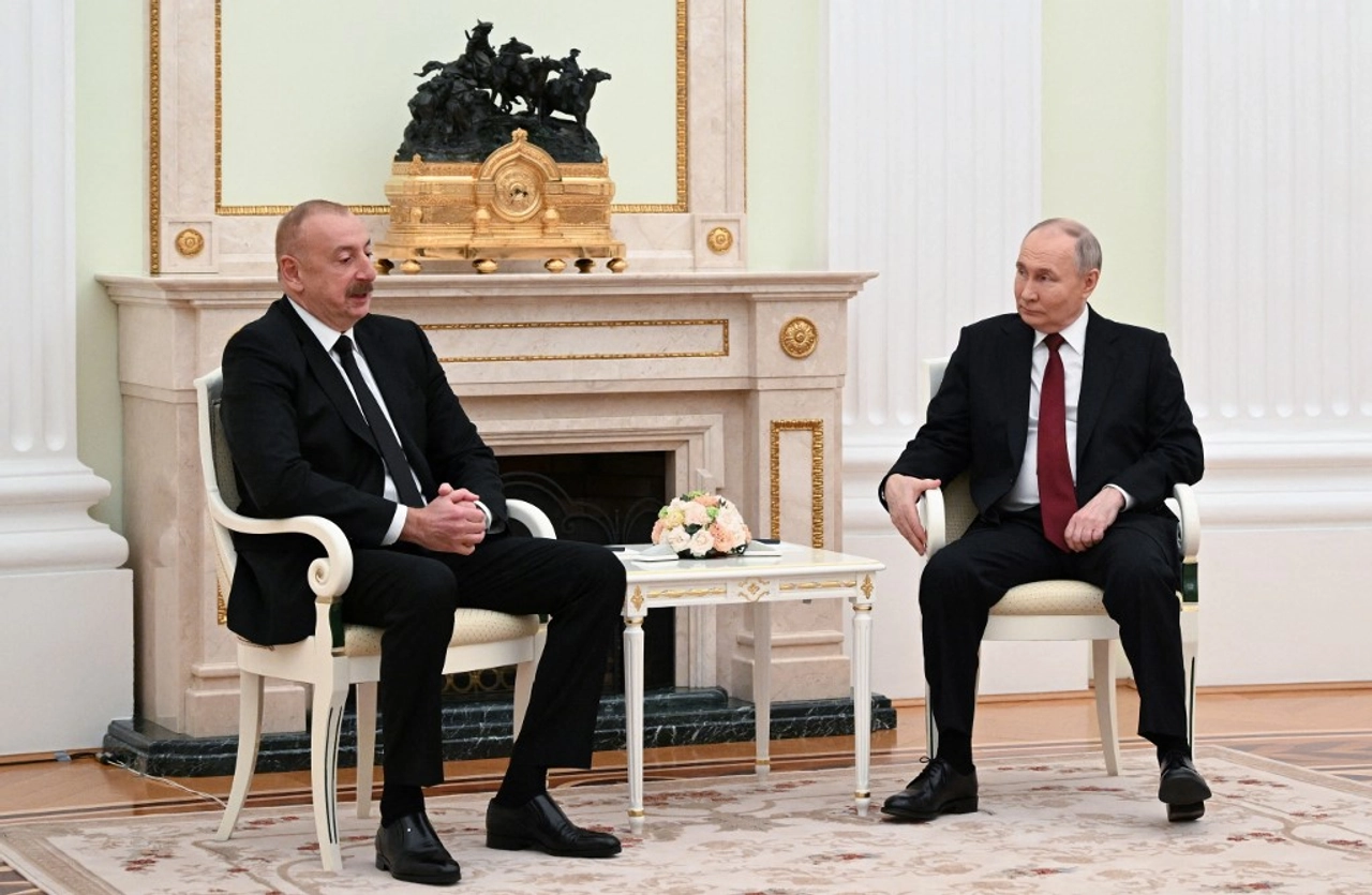 Presidentes Putin e do Azerbaijão sentados, conversando sobre a queda de avião, enquanto Putin pede desculpas sem assumir responsabilidade.