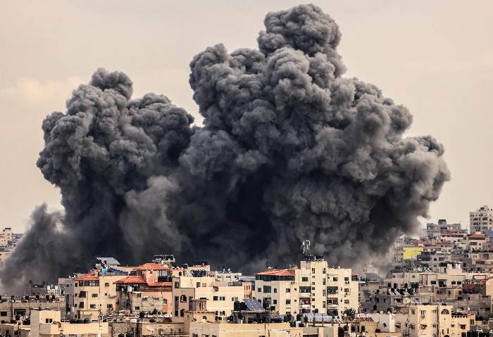 Explosão de fumaça entre prédios após ataque aos Houthis no Iêmen.