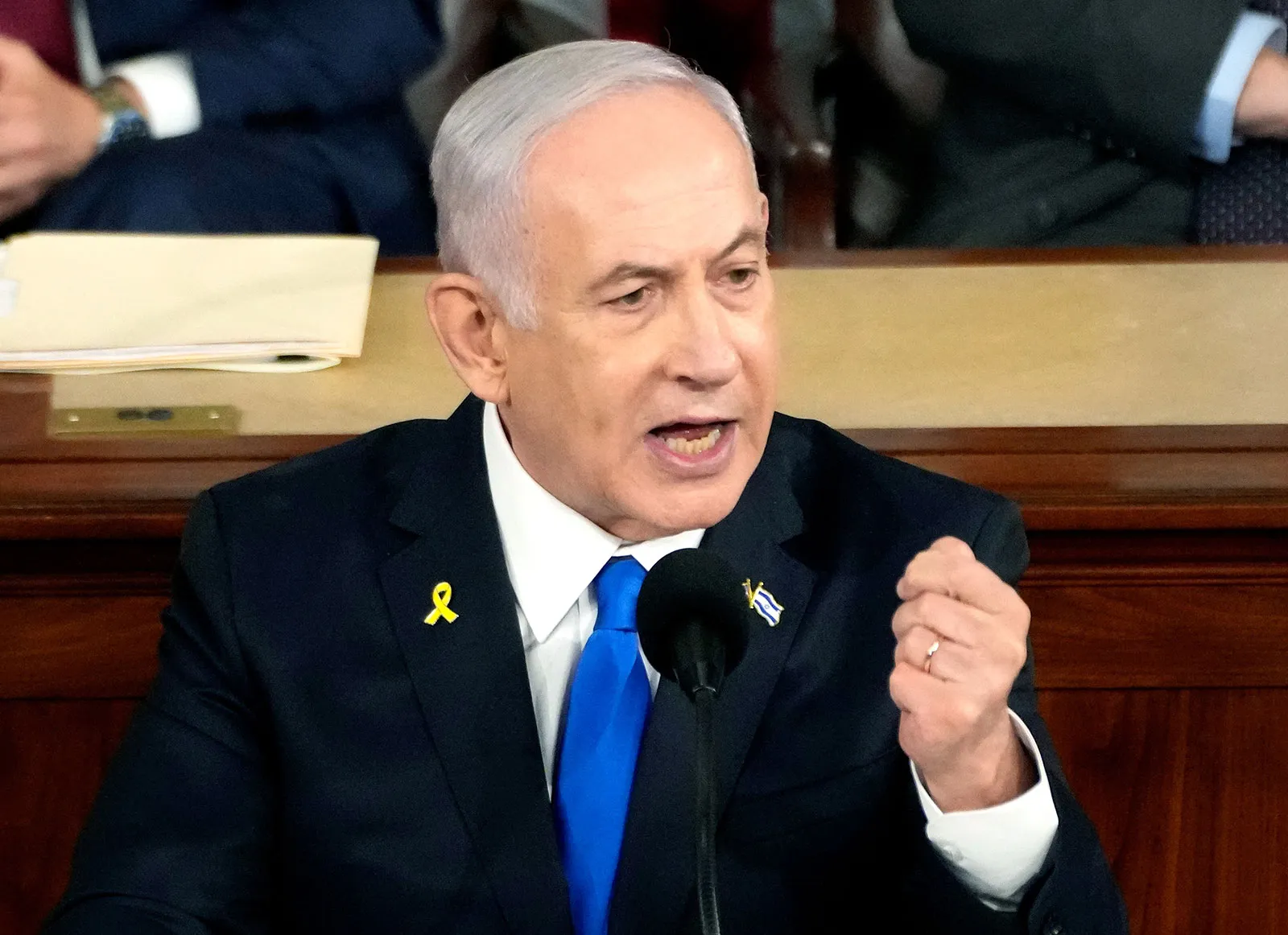 Benjamin Netanyahu discursando com firmeza em uma sala, reforçando a postura de Israel contra os Houthis e o Irã.