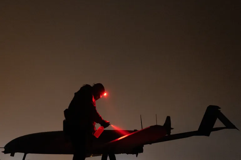 Um membro das forças armadas ucranianas do 14º Regimento de Sistemas Aéreos Não Tripulados prepara um drone de ataque profundo antes de seu lançamento em direção ao território russo [Arquivo: Valentyn Ogirenko/Reuters].