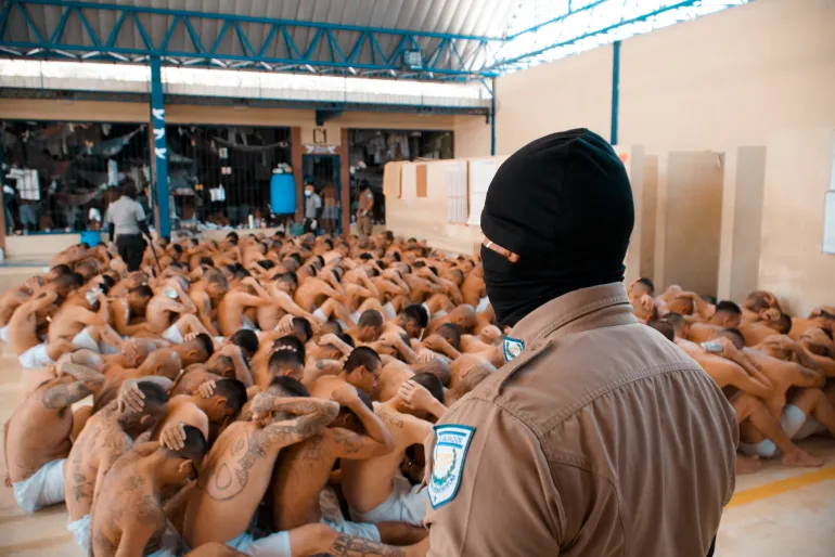 Prisioneiros salvadorenhos são vistos durante uma busca realizada por equipes de segurança nas prisões de Quezaltepeque, no departamento de La Libertad, El Salvador, em março de 2022 [Divulgação/Presidência de El Salvador via Anadolu].