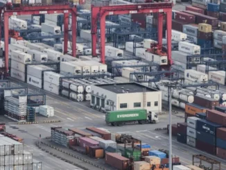 Um caminhão de carga circula entre contêineres empilhados no Porto de Yangshan, em Xangai, China, em 29 de março de 2018 [AP]. Fonte: Al Jazeera