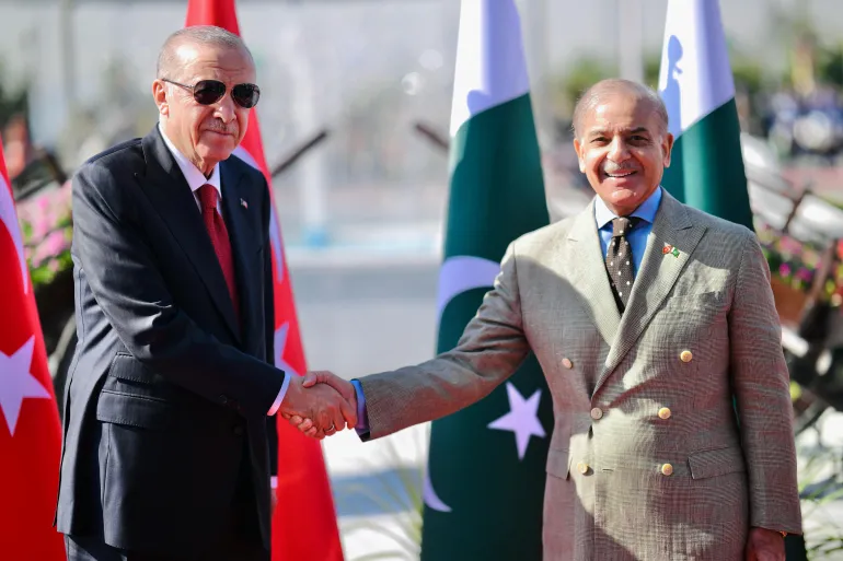 O presidente da Turquia, Recep Tayyip Erdogan, apertando a mão do primeiro-ministro do Paquistão, Shehbaz Sharif, antes de inspecionar uma guarda de honra durante sua recepção cerimonial na Casa do Primeiro-Ministro em Islamabad [Escritório do Primeiro-Ministro do Paquistão / AFP]. Fonte: Al Jazeera