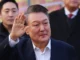 O presidente sul-coreano destituído, Yoon Suk Yeol, acena para seus apoiadores fora do Centro de Detenção de Seul em Uiwang em 8 de março de 2025 [Yonhap/AFP]. Fonte: Al Jazeera