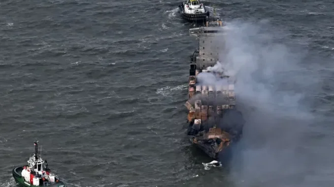 Fumaça sobe do convés do navio cargueiro MV Solong enquanto rebocadores permanecem afastados no Mar do Norte após o navio colidir com o petroleiro MV Stena Immaculate em 10 de março [Arquivo: Paul Ellis/AFP] Fonte: Al Jazeera
