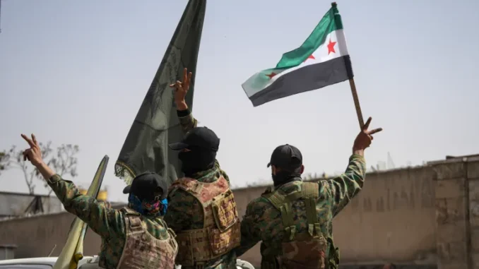Membros das Forças Democráticas Sírias (SDF) fazem o sinal de vitória ao deixar a cidade de Aleppo, Síria, em 9 de abril de 2025.