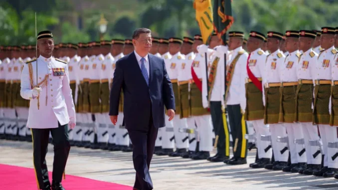Xi Jinping passa em revista uma guarda de honra em frente ao Palácio Nacional da Malásia durante cerimônia oficial de boas-vindas.