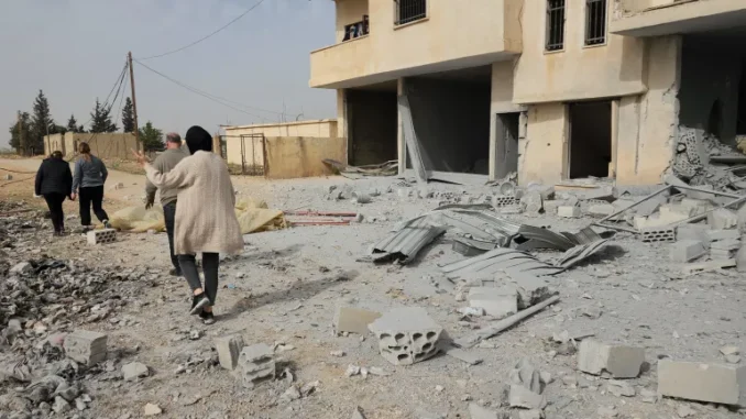 Pessoas caminham entre os destroços de uma área atingida por um ataque aéreo israelense em Hawsh Tal Safiyeh, perto de Baalbek, no Vale do Bekaa, Líbano, em 8 de abril de 2025.