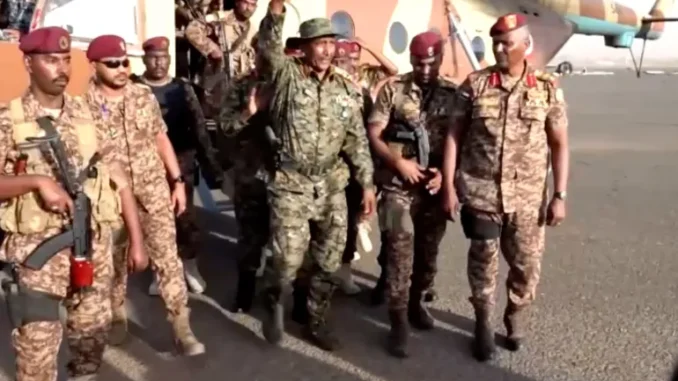 General Abdel Fattah al-Burhan levantando o punho após desembarcar de helicóptero em Cartum, Sudão, em 26 de março de 2025.