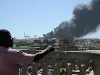 Homem observa a fumaça após ataque de drone em Port Sudan