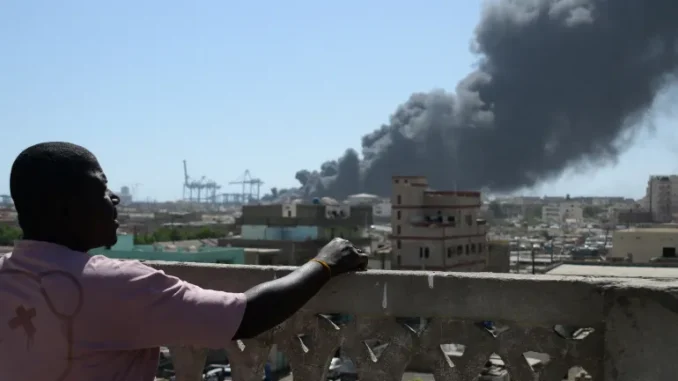 Homem observa a fumaça após ataque de drone em Port Sudan