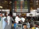 Passageiros aguardam no Aeroporto Internacional de Jinnah após cancelamentos de voos em Karachi.