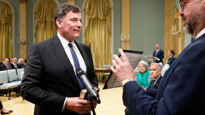Dominic LeBlanc é empossado como ministro das Relações Canadá-EUA, Assuntos Intergovernamentais e Economia Unificada, com o primeiro-ministro Mark Carney ao fundo, durante reformulação do gabinete em Ottawa, 13 de maio de 2025.