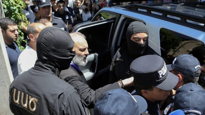 Oficiais da Segurança Nacional da Armênia prendem o arcebispo Bagrat Galstanyan em Yerevan, junho de 2025.