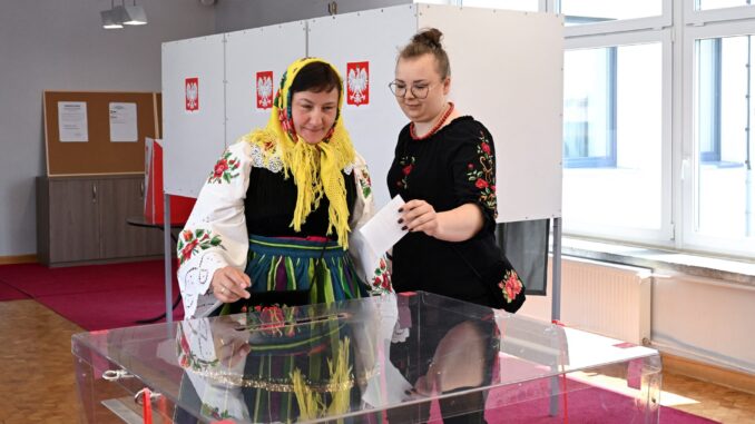 Mulher vestida com roupas tradicionais votando na segunda rodada da eleição presidencial em Gluchow, Polônia, 1º de junho de 2025.