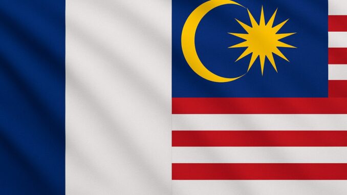 Bandeiras da França e da Malásia lado a lado, representando parceria internacional.
