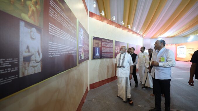 Primeiro-Ministro Narendra Modi visitando a exposição “Filosofia Saiva e as Artes do Templo dos Cholas” com um grupo de pessoas, em um ambiente iluminado e decorado para o evento.