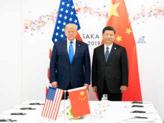 Donald Trump e Xi Jinping posam lado a lado em frente às bandeiras dos EUA e da China durante a cúpula do G20 em Osaka, Japão, em 2019.