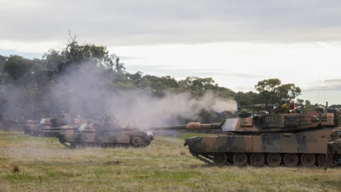 Soldado do Exército Australiano dispara metralhadora pesada .50 a partir de um tanque M1A1 Abrams durante exercício militar em Victoria, Austrália.