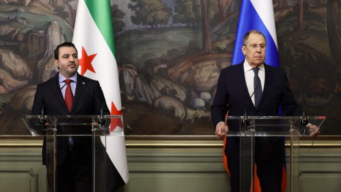 Ministros das Relações Exteriores da Síria e da Rússia, Asaad al-Shibani e Sergey Lavrov, lado a lado durante coletiva de imprensa em Moscou, com bandeiras nacionais ao fundo.