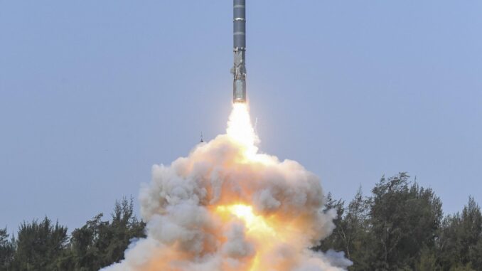 Lançamento de míssil hipersônico russo durante teste militar, com rastro de fogo iluminando o céu ao entardecer.