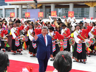 Xi Jinping acenando durante apresentação cultural em Tianjin, com grupo de artistas em trajes tradicionais comemorando a cúpula da OCX.