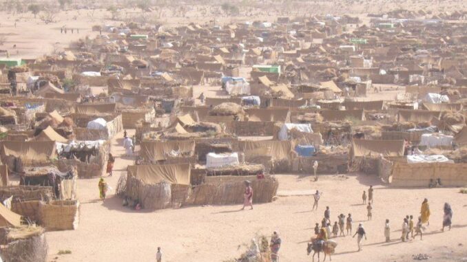 Campo de refugiados em Darfur, Chade, mostrando tendas e pessoas deslocadas em situação vulnerável.