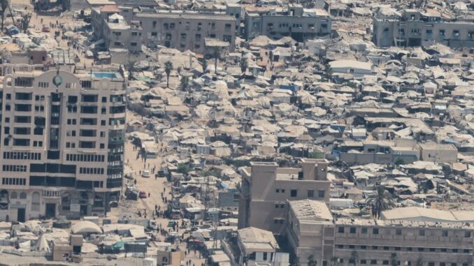 Vista aérea da cidade de Gaza mostrando prédios destruídos e ruas lotadas de destroços após ataques recentes.