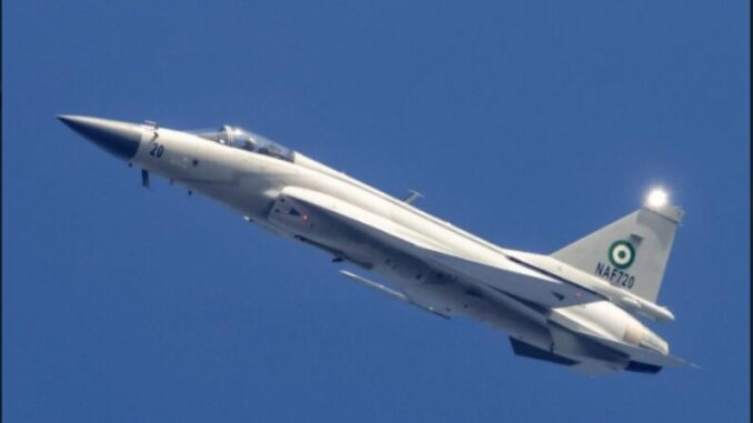 Caça JF-17 branco da Força Aérea da Nigéria voando contra céu azul claro