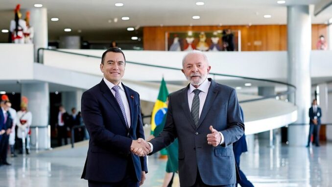 Lula e Daniel Noboa apertando as mãos no Palácio do Planalto, com a bandeira do Brasil ao fundo e oficiais em cerimônia oficial.