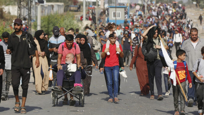 Palestinos fugindo de suas casas em Gaza em novembro de 2023, incluindo crianças, idosos e pessoas com mobilidade reduzida, carregando pertences pessoais.