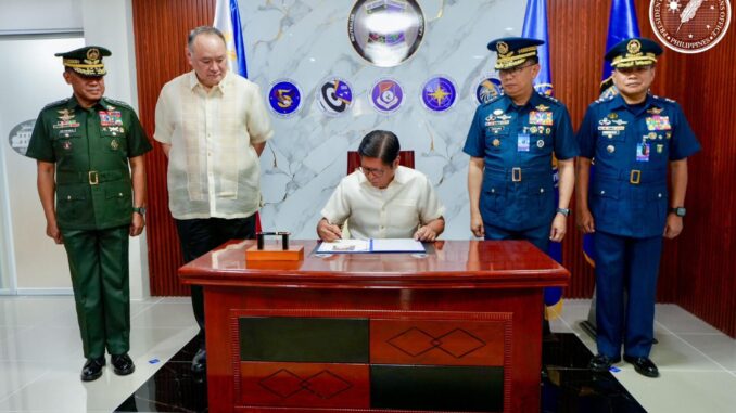 O presidente das Filipinas, Ferdinand R. Marcos Jr., assina documento enquanto é observado por oficiais da Força Aérea e do Exército das Filipinas durante cerimônia de homenagem à Força Aérea do país.