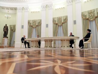 Vladimir Putin e Ebrahim Raisi sentados à mesa durante reunião diplomática no Kremlin, 19 de janeiro de 2022