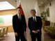 Ministro japonês Takeshi Iwaya com o Ministro das Relações Exteriores da Hungria em reunião oficial, com bandeiras do Japão e Hungria ao fundo.