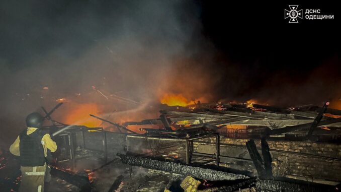 Soldado ucraniano combate incêndio em prédio destruído durante ataque noturno russo com drones e mísseis.
