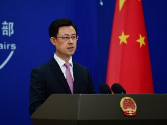 Porta-voz do Ministério das Relações Exteriores da China falando em coletiva com a bandeira chinesa ao fundo, reafirmando política de “Uma Só China” e oposição à independência de Taiwan.