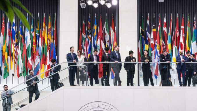 Reunião internacional no prédio do FMI em 25 de junho de 2025, com delegações e bandeiras de diversos países.