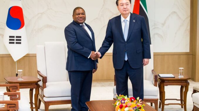 Presidente de Moçambique, Filipe Nyusi, cumprimenta o Presidente da Coreia do Sul, Yoon Suk Yeol, durante encontro oficial em Seul, com bandeiras nacionais ao fundo.