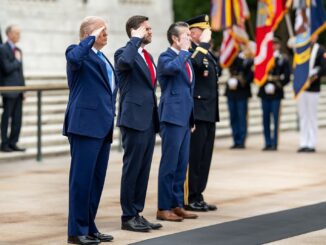 Donald Trump cumprimenta oficiais militares, incluindo Pete Hegseth, durante cerimônia no Cemitério Nacional de Arlington.