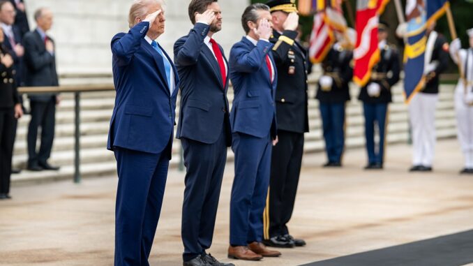 Donald Trump cumprimenta oficiais militares, incluindo Pete Hegseth, durante cerimônia no Cemitério Nacional de Arlington.