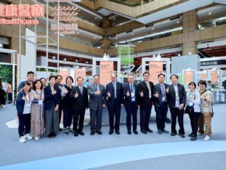 Participantes da feira de inovação e tecnologia em Taiwan posando em estande de exposição, mostrando a colaboração internacional no setor de defesa e tecnologia.