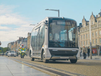 Robobus autônomo da WeRide circulando pelas ruas de Leuven, Bélgica, com pedestres e veículos ao redor.