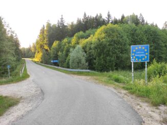 Fronteira entre Polônia e Lituânia mostrando a estrada e a paisagem natural ao redor, sem infraestrutura de controle.