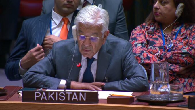 Khawaja Asif discursando no Conselho de Segurança da ONU, com uma mulher sentada atrás dele durante a sessão.