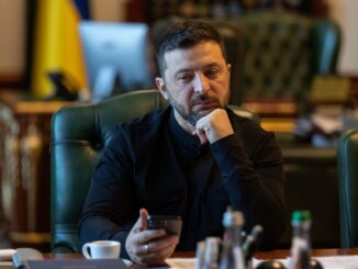 Presidente ucraniano Volodymyr Zelensky olhando para o celular enquanto reflete em seu escritório, 12 de outubro de 2025.