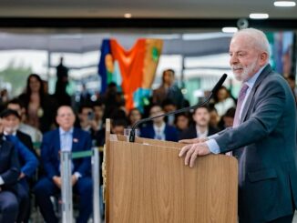 Presidente Luiz Inácio Lula da Silva discursando em evento sobre reforma habitacional, com público ao fundo.