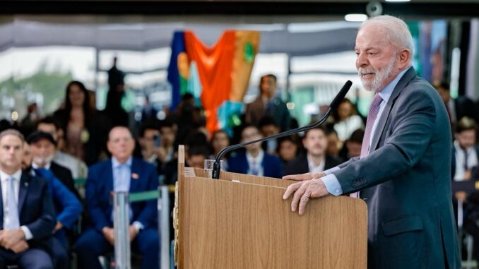 Presidente Luiz Inácio Lula da Silva discursando em evento sobre reforma habitacional, com público ao fundo.