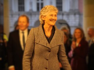 Catherine Connolly sorrindo enquanto caminha, momentos após saber que venceu a eleição presidencial da Irlanda em 2025.