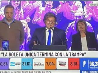 Políticos no palco durante discurso pós-eleição na Argentina com painel de resultados ao fundo.