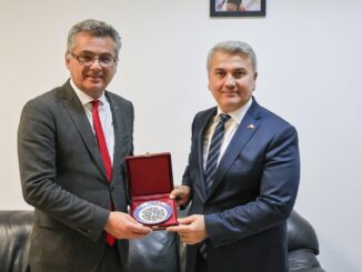 Tufan Erhürman e Dr. Mustafa Canbey segurando um prato comemorativo durante reunião em 26 de fevereiro de 2025.